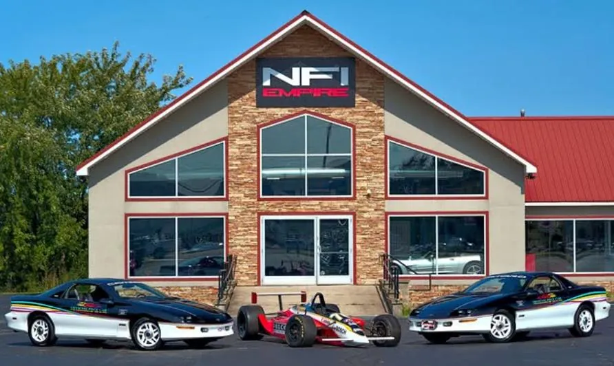 The NFI Empire Clubhouse with classic and race cars out front