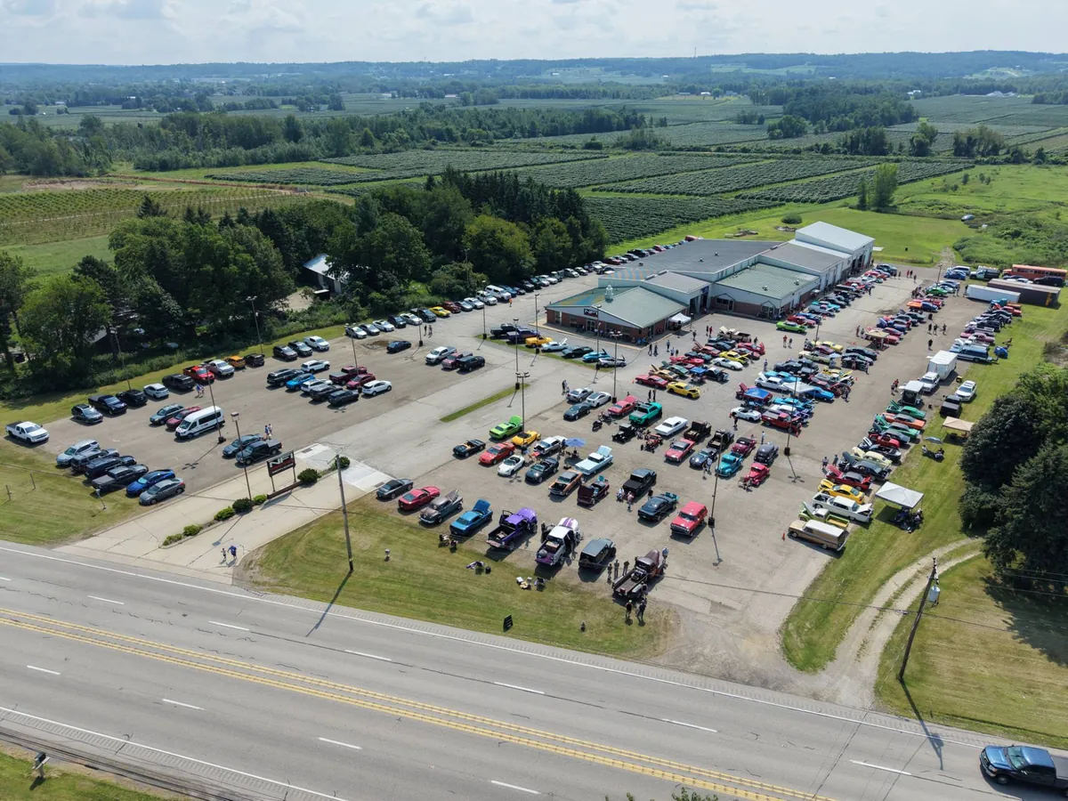 Aerial view of the NFI Empire location during a car show, its lot full of classic cars