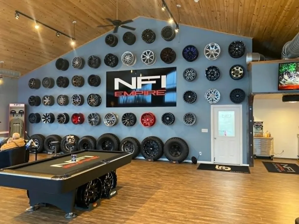 The Clubhouse showroom wall of wheels under the NFI Empire sign