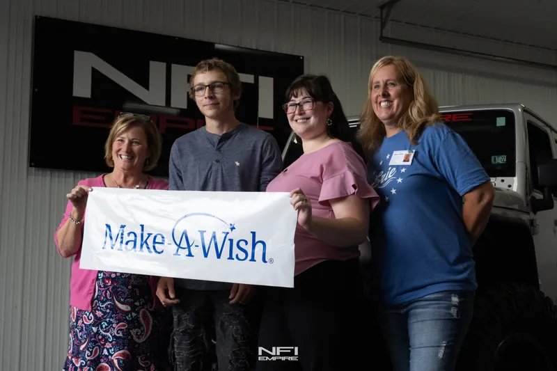 Family, Make-A-Wish and the NFI Empire team with the Make-A-Wish banner