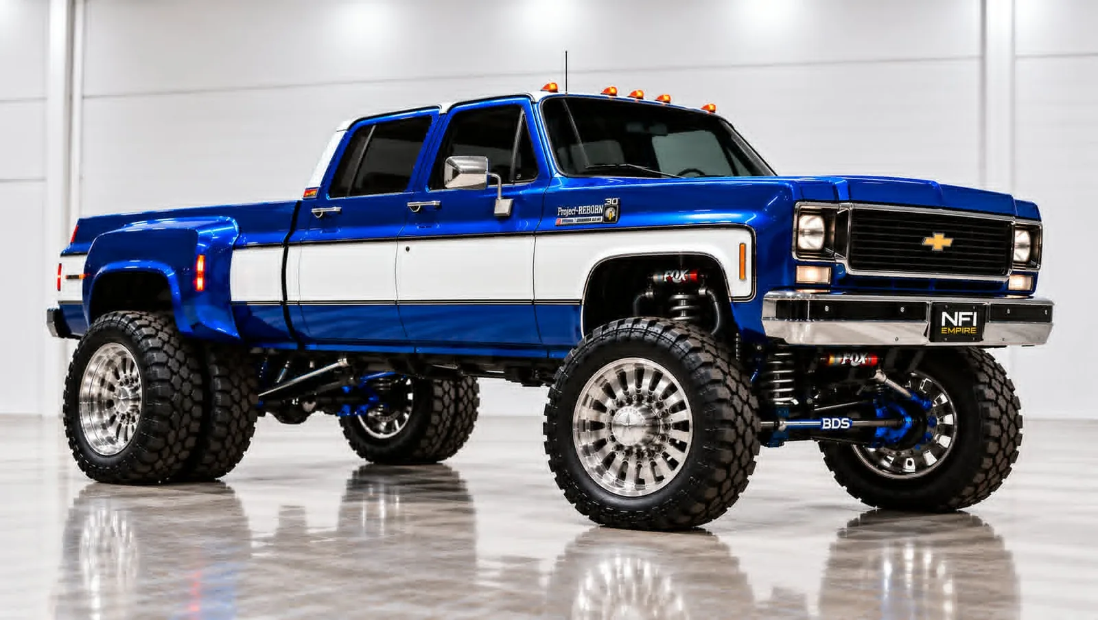 Project REBORN-001, a blue and white 1979 Chevrolet K30 crew cab dually on polished wheels in a white studio